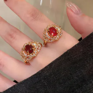 Primo piano di anelli placcati oro 18 carati con pietre rosse e zirconi scintillanti.
