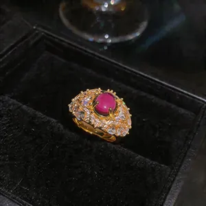 Dettaglio di un anello placcato oro 18K con cabochon rosa vibrante e accenti di zirconi.
