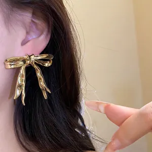 Elegant gold bow ribbon stud earrings for women with high-shine vintage finish