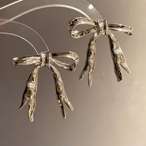 Vintage glossy silver bowknot pendant earrings for a light luxury fashion look