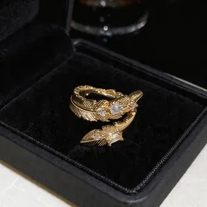 Primo piano di un anello a piuma placcato oro 18K con pietre di zirconia