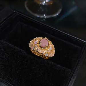 Vista macro dettagliata dell'anello placcato oro 18K con pietra rosa e motivo a piuma
