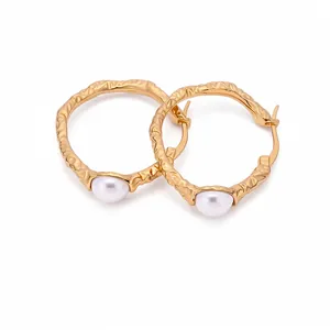 Elegant gold crumpled hoop earrings with pearl accents on a white background.