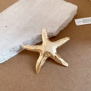 Detailansicht einer luxuriösen goldenen Seestern-Brosche mit Vintage-Faltenstruktur