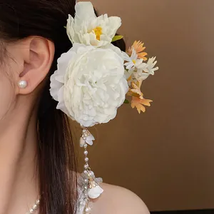 Close-up detail of fabric flower hair clip with elegant pearl tassels in sweet style