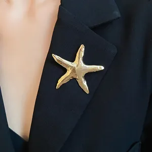 Detailansicht einer goldenen Vintage-Seestern-Brosche mit einzigartiger Knitterstruktur.