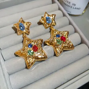 Elegant gold star drop earrings featuring colorful rhinestones and unique wrinkled metal texture