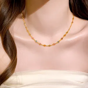 Close-up detail of a minimalist necklace featuring colorful resin beads on a model