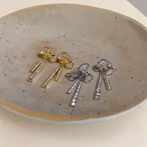 Élégantes boucles d'oreilles clips nœud or et argent avec pompons en zircone scintillants