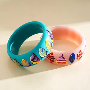 Detailansicht lebendiger Dopamin-Resin-Armreifen mit bunten tropischen Fischmotiven
