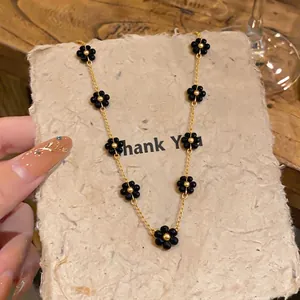 Elegant gold chain necklace featuring delicate black beaded flower charms for women