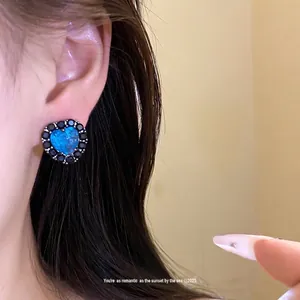 Elegant heart-shaped stud earrings with blue textured stone and black zircon border