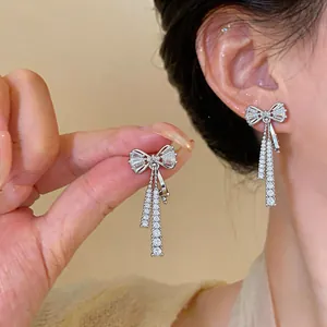Boucles d'oreilles clips nœud en argent avec pompons en zircone étincelants sur l'oreille