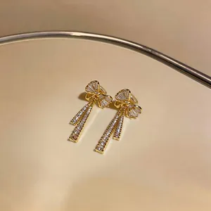 Vue détaillée de boucles d'oreilles nœud plaquées or avec zircons brillants