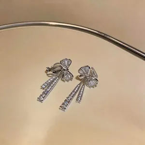 Détail de boucles d'oreilles clips nœud en zircone cubique avec finition argentée.