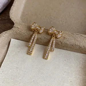 Gros plan d'élégantes boucles d'oreilles clips nœud en or 14k avec des zircons cubiques