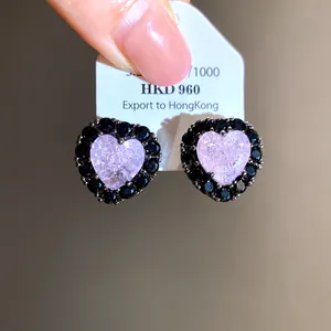 Close-up of elegant heart-shaped stud earrings featuring pink core and black stones