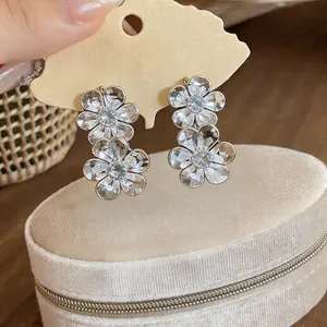 Close-up of elegant floral zircon stud earrings featuring a minimalist metallic design.