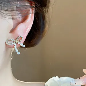 Elegant 14k gold plated bow earrings featuring small pearls and micro-pave crystals