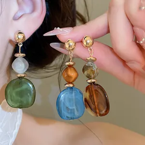 Primer plano detallado de elegantes pendientes geométricos de resina veteada en modelo