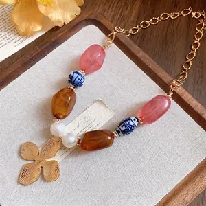 Elegant vintage beaded necklace with a golden flower pendant, ceramic and resin beads