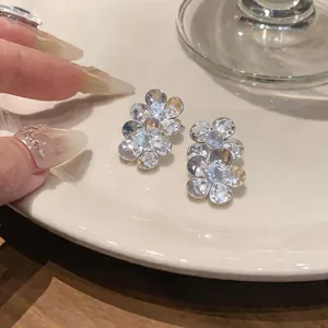 Close-up detail of silver floral stud earrings with sparkling clear cubic zirconia.