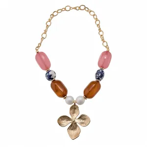 Vintage court-style necklace featuring colorful ceramic beads and a large gold flower pendant