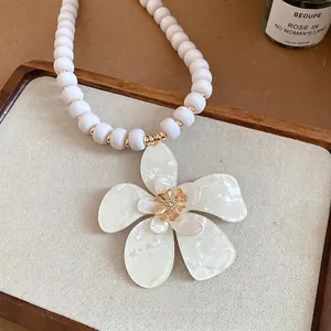 French vintage beaded necklace with a large white resin flower pendant and gold accents