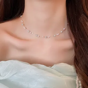 Close-up view of a minimalist pearl and crystal choker on an elegant female model.
