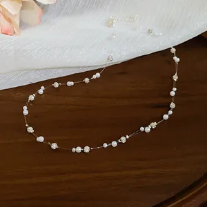 Detailed view of delicate small pearls and sparkling rhinestone beads on an invisible thread.