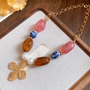 Close-up detail of vintage ceramic and pearl beaded necklace with gold flower pendant