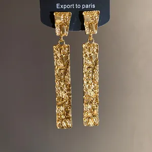 Detailed view of elegant golden rectangular earrings with a unique crumpled texture finish