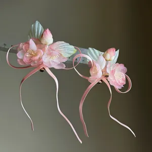 Close-up of pink gauze flower hair clips with long ribbons and size ruler