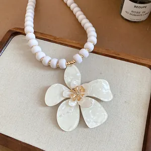 Close-up view of a French retro beaded necklace featuring an elegant white flower pendant.