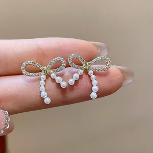Detailed macro view of gold plated bow stud earrings with sparkling pavé and pearls