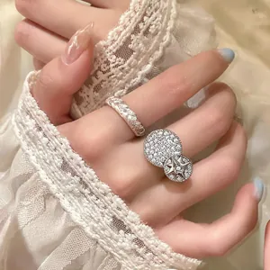 Close-up detail of elegant silver twisted band and star zircon paved rings on hand
