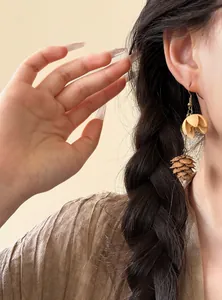 Close-up view of vintage ethnic style dangle earrings with nut-shaped beads on an Asian model