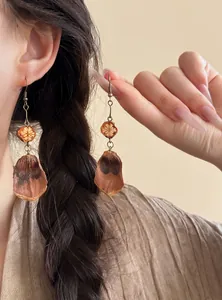 Detailed macro view of ethnic handmade earrings with natural dried fruit slices and seeds