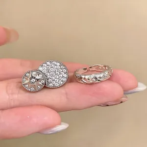 Detailed view of silver zircon twisted braid open ring and starburst disc ring set