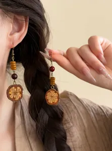 Detailed view of vintage fruit slice beaded drop earrings with ethnic style worn by a model