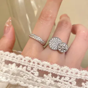 Macro view of silver-toned braided ring and zircon-paved star motif open ring