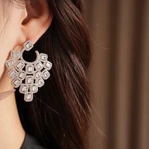 Exquisite close-up of geometric square zircon statement earrings worn on a female ear
