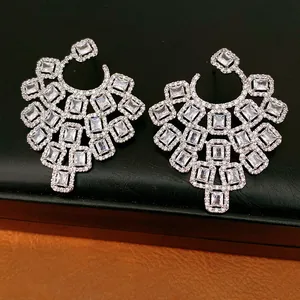 Detailed view of geometric chandelier earrings with clear square cubic zirconia stones