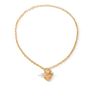 Detail view of a gold stainless steel necklace with heart pendant and pearl charm.