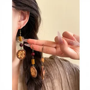 Close-up detail of vintage ethnic earrings with wooden fruit slices and red beads