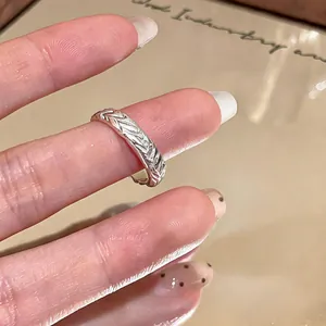 Close-up of a silver twisted wheat-patterned ring shown on a finger in detail.