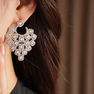 Close-up of luxury silver earrings featuring intricate geometric cubic zirconia settings