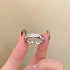 Detailed view of an adjustable silver-colored twisted rope ring featuring sparkling zircon stones