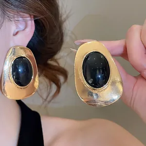 Statement vintage gold oval earrings featuring large black resin center for women