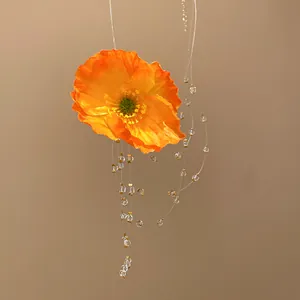 Nahaufnahme einer leuchtend orangefarbenen Mohnblumenkette mit feinen Perlenquasten